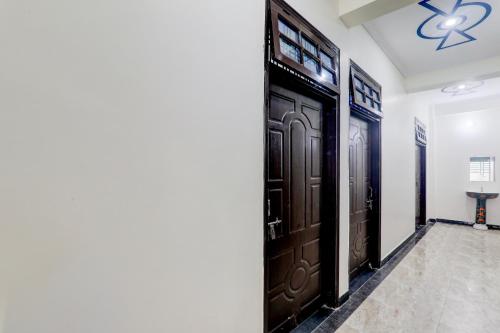 a hallway with brown doors and a ceiling at OYO 83128 Kp Guest House in Bāra Banki