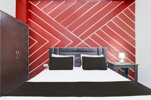 a bedroom with a bed with a red wall at OYO 83128 Kp Guest House in Bāra Banki