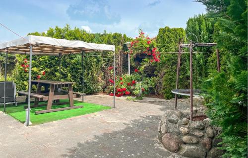a garden with a picnic table and a swing at 1 Bedroom Gorgeous Home In Mscice in Mścice