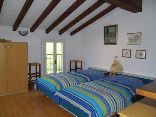 een slaapkamer met drie bedden met blauwe en gele strepen bij B&B Smile in Fiorano Modenese
