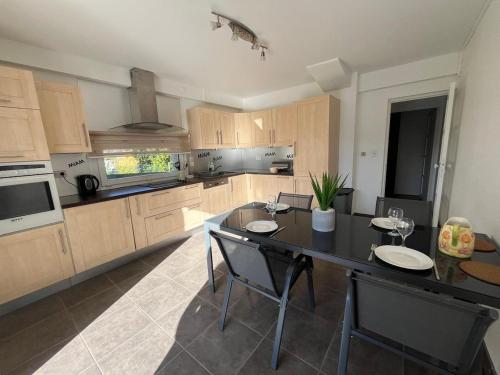 a large kitchen with a table and chairs in it at appartement tout confort dans villa avec piscine in Cébazat