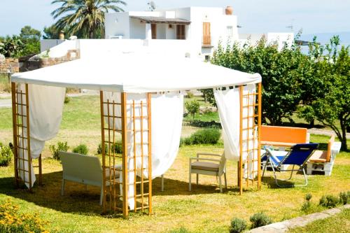 a gazebo with chairs under it in a yard at La Sirena in Panarea