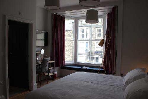 - une chambre avec un lit et une grande fenêtre dans l'établissement The Tilman, à Barmouth