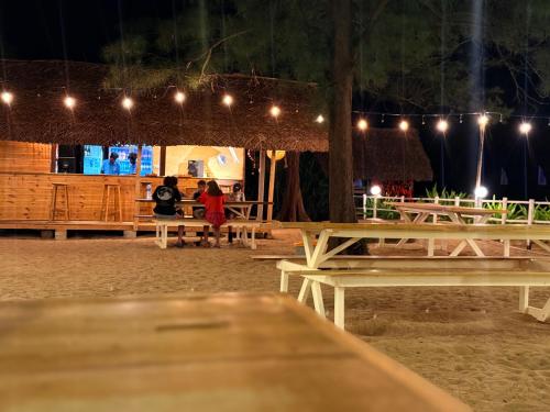 a group of people sitting on picnic tables at night at Hotel Coral Bay in Trincomalee