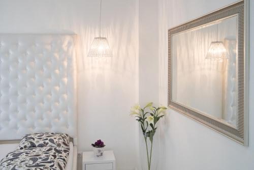a white bedroom with a bed and a vase of flowers at Sofia Apartment in Budapest