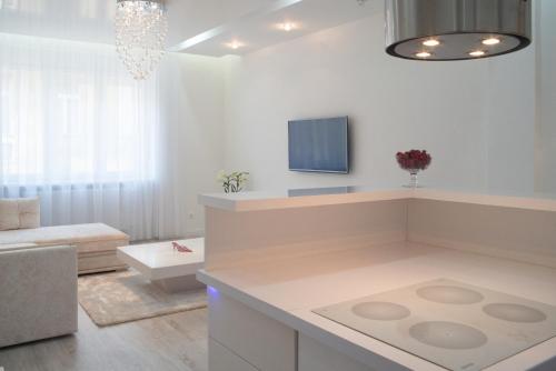 a white living room with a couch and a tv at Sofia Apartment in Budapest