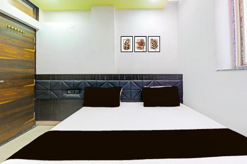 a bed in a room with two pillows at Collection O Sheesh Mahal Hotel in Patna