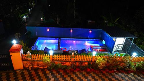 a house with a large swimming pool at night at Arabian Nights Munnar Pool Villa in Munnar