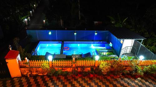 a large swimming pool in a house at night at Arabian Nights Munnar Pool Villa in Munnar