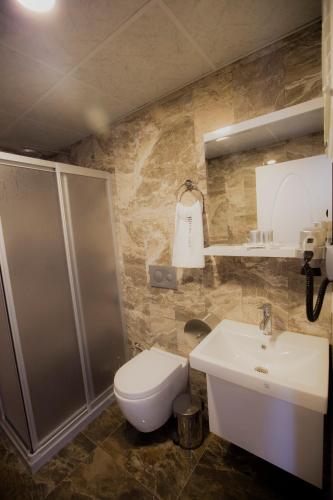 a bathroom with a shower and a toilet and a sink at Royal İnci Hotel in Istanbul