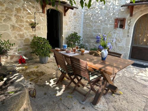 a wooden table and chairs with flowers on it at Old stone villa in Apokoronas Villa Nostalgia Kreta in Fílippos