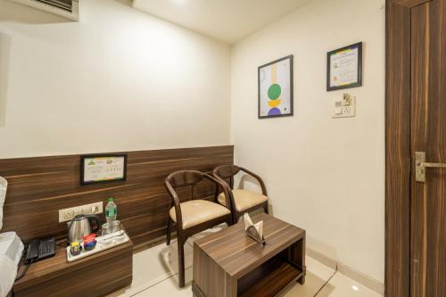 a hotel room with a chair and a desk at Treebo Ashirwad Regency in Bhopal
