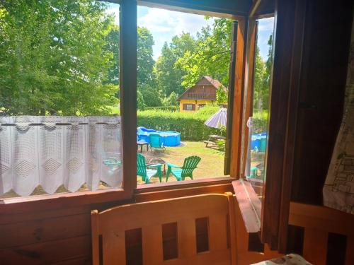 a window with a view of a yard with a house at The Hideaway in Želiv