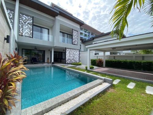 a swimming pool in the backyard of a house at Serenity Jomtien Pool Villas in Jomtien Beach
