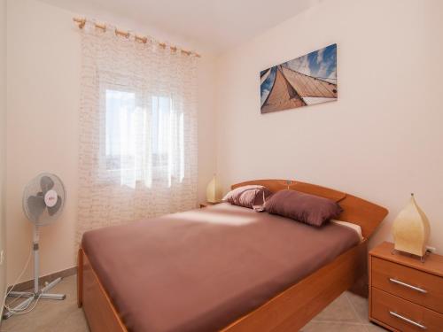 a bedroom with a bed and a window at Apartment Mare visum in Peroj