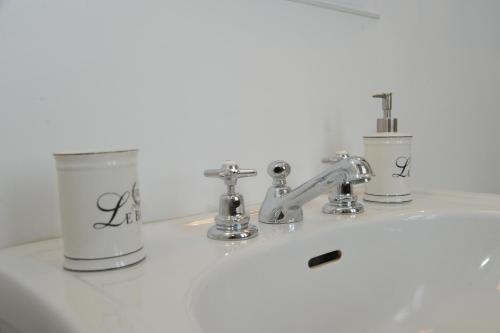 a bathroom sink with two cups and a faucet at La Mainolda B&B in Mantova