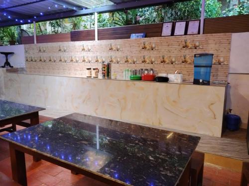 a counter in a restaurant with two tables in front at Arabian Nights Munnar Pool Villa in Munnar