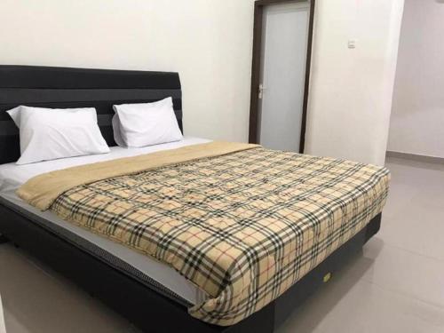 a bedroom with a bed with a checkered blanket at OYO 92468 Roemah Djatinegara in Jakarta