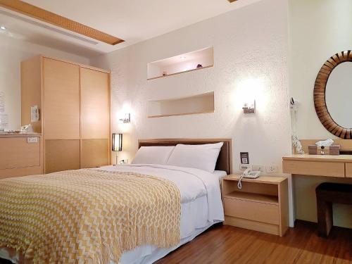 a bedroom with a bed and a desk with a phone at 日月潭水社海民宿 in Yuchi