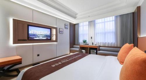 a hotel room with a bed and a flat screen tv at Chengdu Haotian Guotai Hotel in Chengdu
