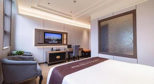 a hotel room with a bed and a chair and a desk at Chengdu Haotian Guotai Hotel in Chengdu