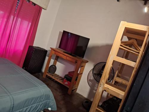 ein Schlafzimmer mit einem Bett und einem TV auf dem Tisch in der Unterkunft casa en escobar con cocheras in Belén de Escobar
