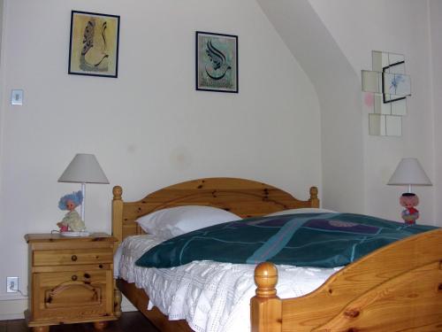1 dormitorio con cama de madera y mesita de noche con 2 lámparas en Gîte Labaroche Temps Libre, en Labaroche