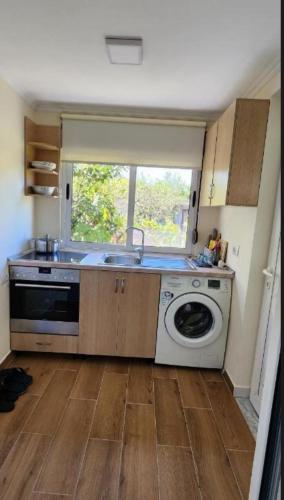 a kitchen with a sink and a washing machine at Apartament Teuta in Përmet