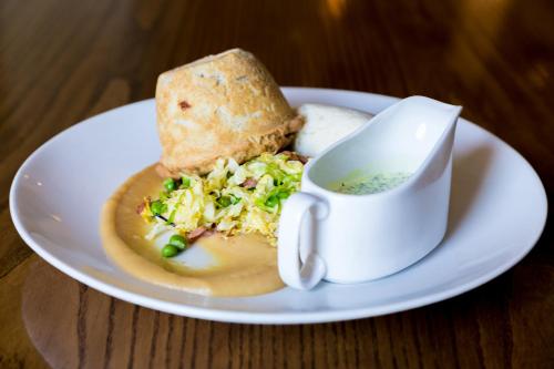 a plate with a sandwich and a cup of soup at The White Hart Hotel in Welwyn