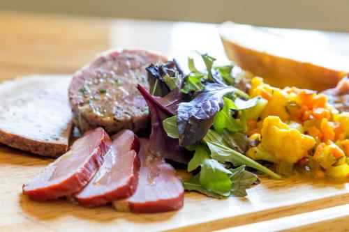 a plate of food with meat and vegetables on a table at The White Hart Hotel in Welwyn