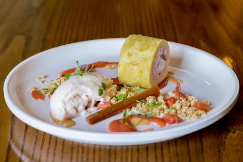 a white plate of food with a sandwich and vegetables at The White Hart Hotel in Welwyn
