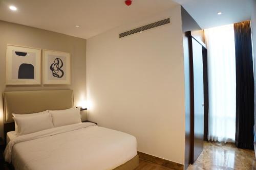 a bedroom with a white bed and a window at Empyrean Dhaka City Centre in Dhaka