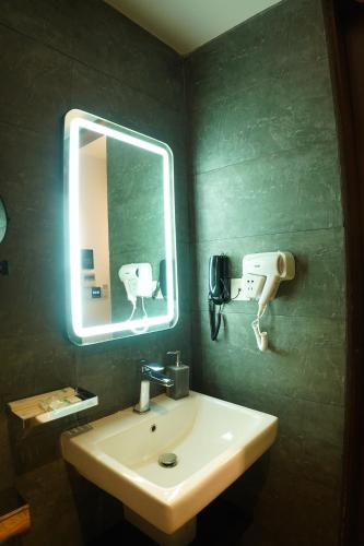 a bathroom with a sink and a mirror at Empyrean Dhaka City Centre in Dhaka