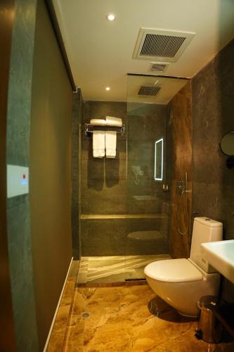 a bathroom with a toilet and a shower and a sink at Empyrean Dhaka City Centre in Dhaka