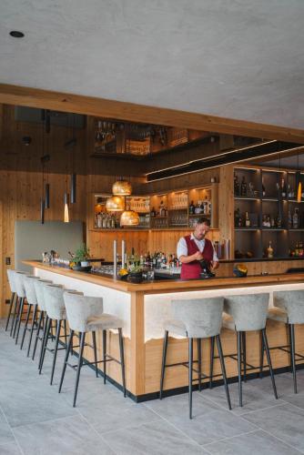 a woman standing at a bar in a restaurant at Hotel Acherl in Achenkirch