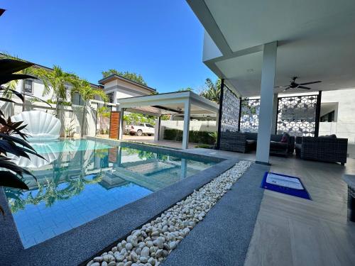 a house with a swimming pool and a house at Serenity Jomtien Pool Villas in Jomtien Beach