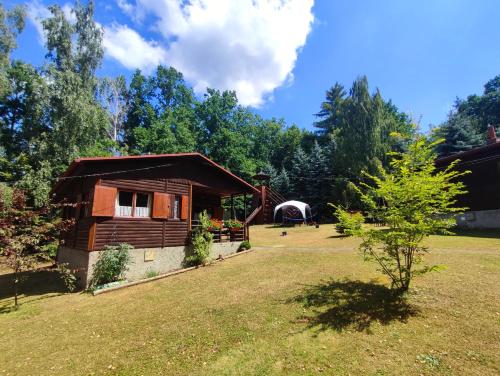 a log cabin in a yard with a tree at The Hideaway in Želiv