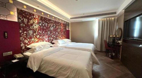 a hotel room with two beds and a tv at Jinjiang Metropolo Shanghai Minhang in Shanghai