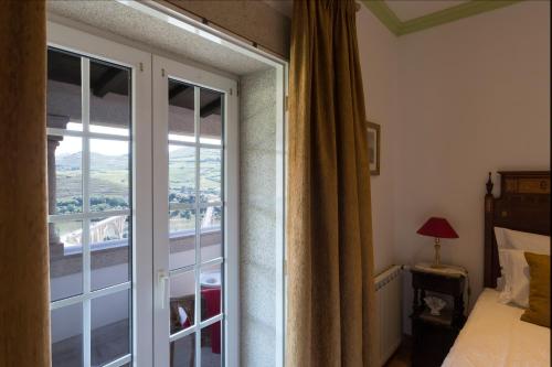 a bedroom with a sliding glass door to a balcony at Casa de São Domingos in Peso da Régua