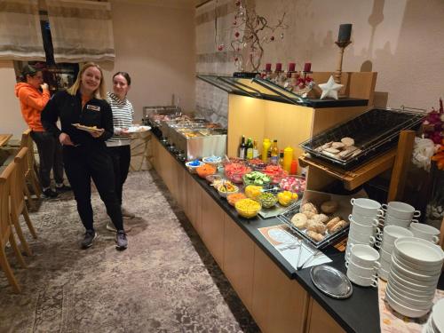 two women are standing in a kitchen with food at Garden Depandance Am Bach in Kurort Altenberg
