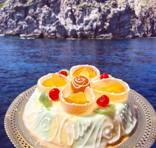 a cake with fruit on it sitting on a plate at Borbon Home luxury rooms & SPA in Palermo