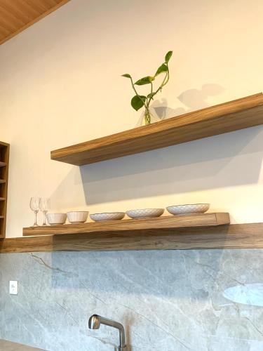 a shelf above a sink with bowls and a plant at Villa Teduh Canggu in Dalung