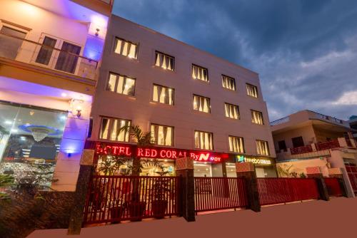 a tall white building with a red sign on it at Treebo Red Coral in Haridwār
