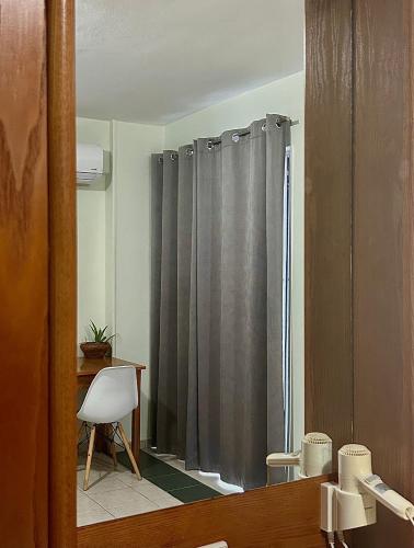 a bathroom with a shower curtain and a mirror at Andromeda Apartments & Studios in Hersonissos