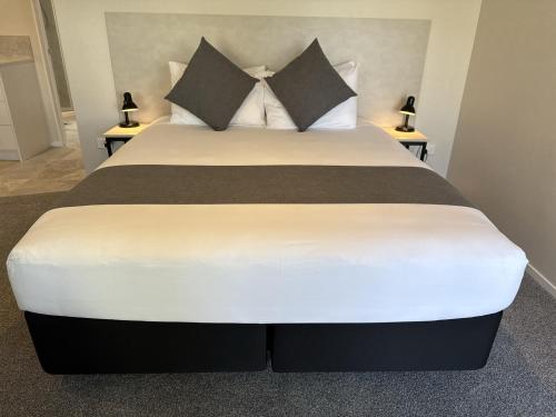 a bedroom with a large bed with two night stands at BKs Pioneer Motel in Auckland