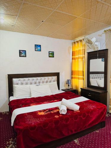 a bedroom with a large bed with a red blanket at Skardu Baltistan Village Guest House in Skardu