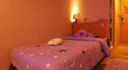 a bedroom with a purple bed with stars on it at Cozy Hotel Xiamen in Xiamen