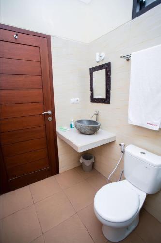 a bathroom with a toilet and a sink at Villa Popolan and Guest House in Ubud