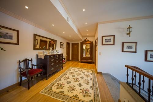 a hallway with a table and a chair and a rug at Casa de São Domingos in Peso da Régua