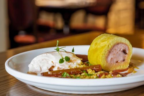 a plate of food with ice cream and a piece of bread at The White Hart Hotel in Welwyn